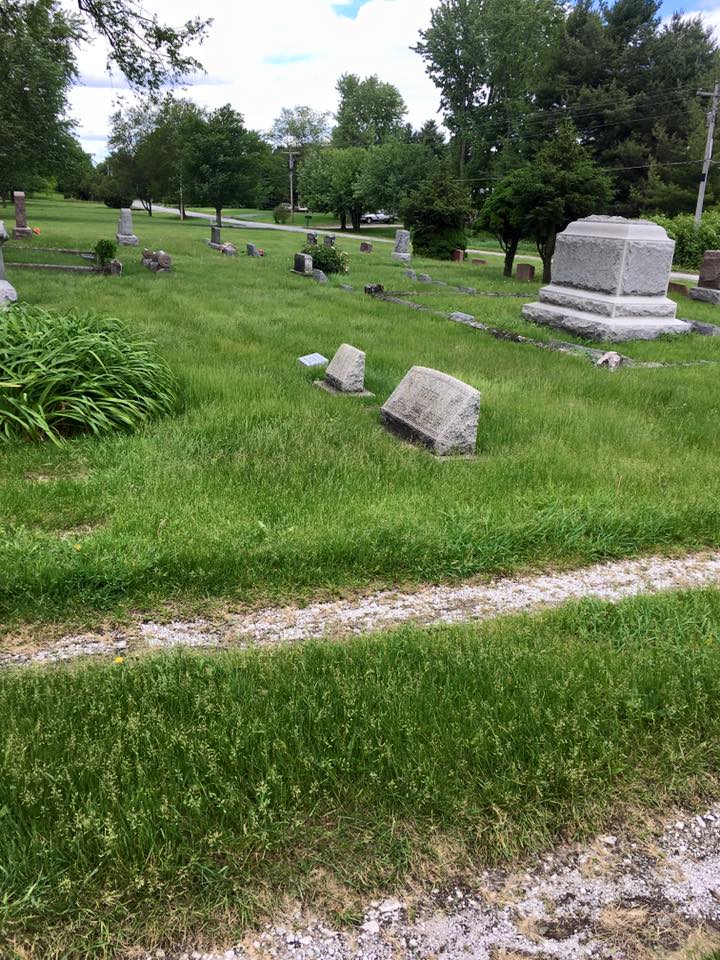 Ground-level visitor view across grass pathways and memorial stones.