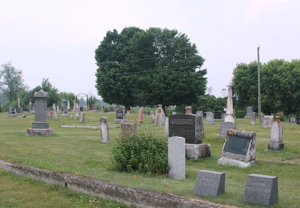 Tree-lined view across memorial stones at Admaston Cemetery.